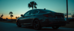 Dark sedan with heavily tinted windows parked on a Florida road at dusk, illustrating Florida window tint law